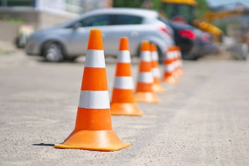 Traffic cones placed on a road, indicating a construction zone or detour for vehicles.